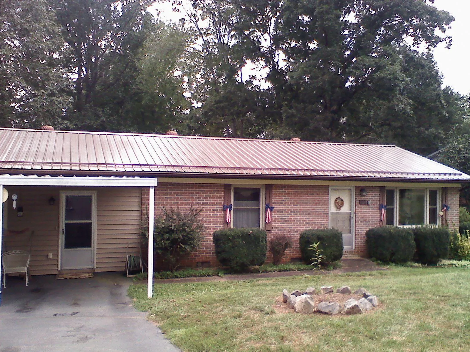 Bronze metal roof and carport on a brick ranch home — Roof Repair work by our crew in Orleans